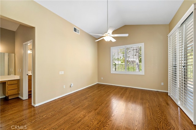 unfurnished bedroom featuring lofted ceiling, ceiling fan, hardwood / wood-style flooring, and ensuite bathroom