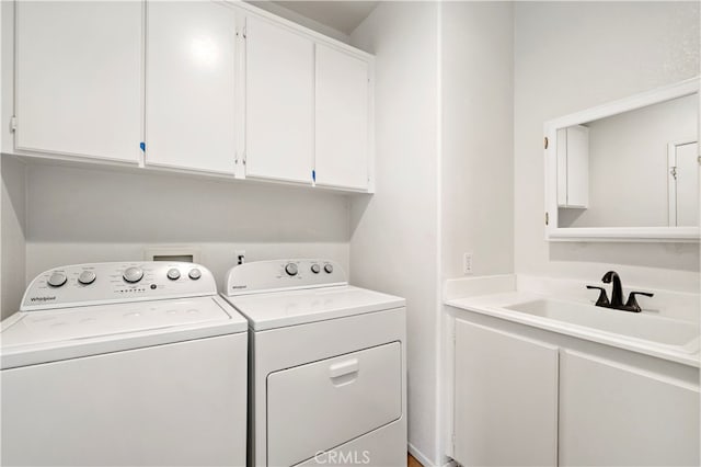 laundry area featuring sink, washer and dryer, and cabinets