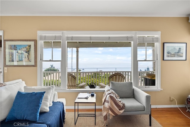 sitting room with ornamental molding, hardwood / wood-style floors, and a healthy amount of sunlight