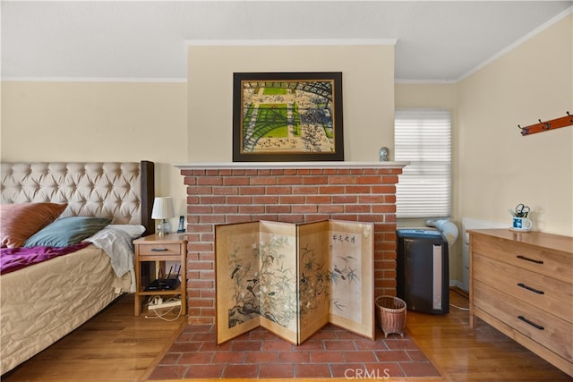 bedroom featuring a brick fireplace, dark hardwood / wood-style floors, and ornamental molding