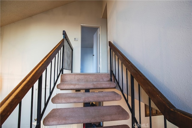 staircase with lofted ceiling