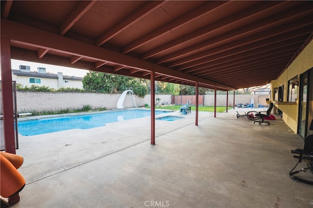 view of swimming pool with a water slide and a patio area