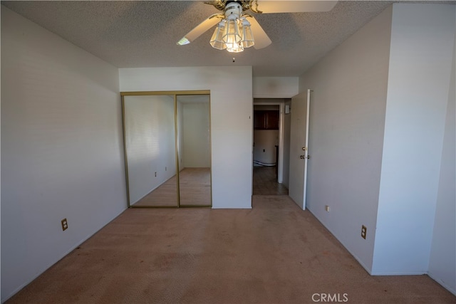 unfurnished bedroom with light carpet, a closet, a textured ceiling, and ceiling fan