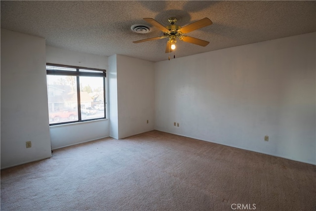 carpeted spare room with a textured ceiling and ceiling fan