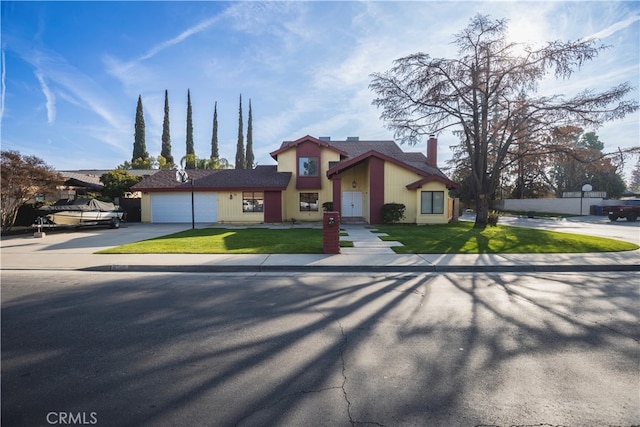 view of front of property featuring a front lawn and a garage