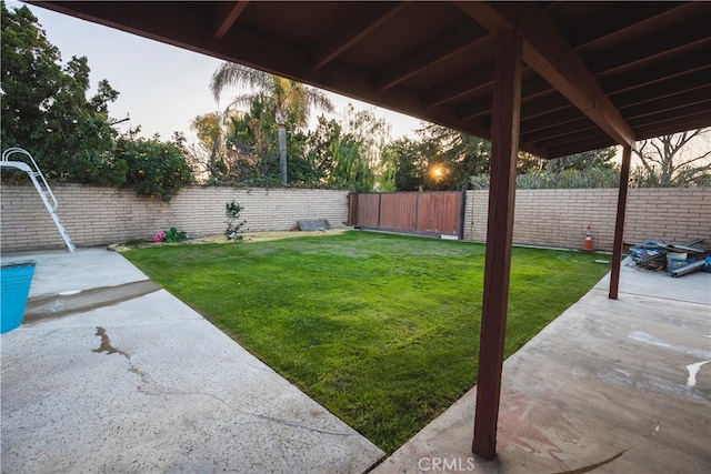 yard at dusk featuring a patio area