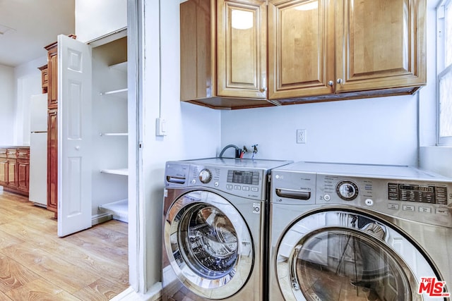 laundry room with cabinets, independent washer and dryer, and light hardwood / wood-style flooring