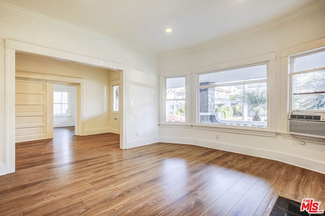 spare room featuring cooling unit, ornamental molding, and hardwood / wood-style flooring