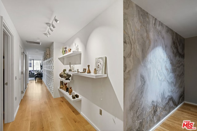 corridor featuring track lighting and light hardwood / wood-style flooring