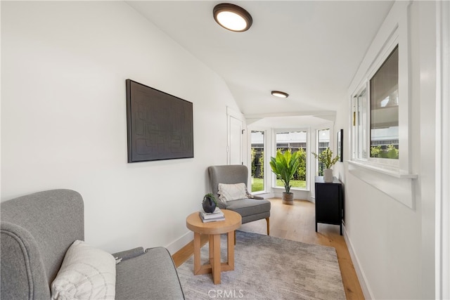 sitting room with light hardwood / wood-style floors and vaulted ceiling