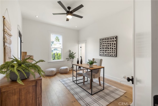 home office with ceiling fan and light hardwood / wood-style floors