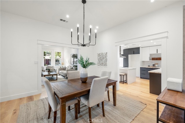 dining area featuring light wood-type flooring and an inviting chandelier