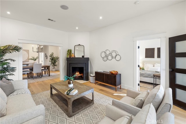 living room featuring light wood-type flooring and a fireplace