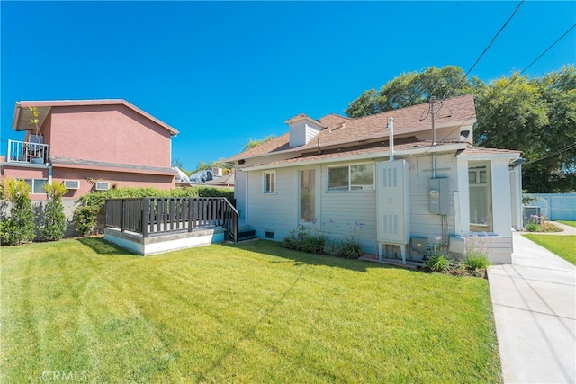 back of property with a lawn and a deck