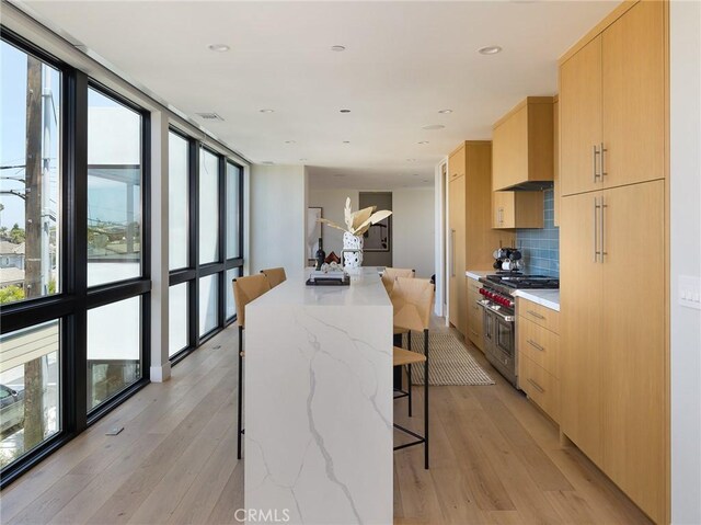 3100 Tennyson Pl, Hermosa Beach, CA 90254 - kitchen with range with two ovens, light brown cabinetry, modern cabinets, plenty of natural light, and a wall of windows