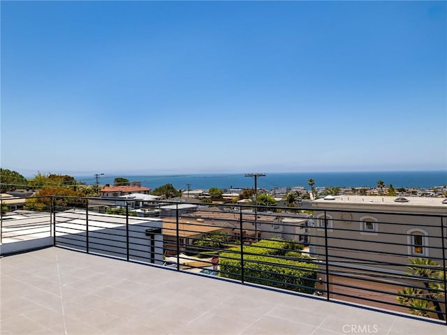 view of patio featuring a water view and a balcony