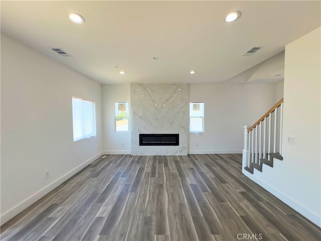 unfurnished living room featuring a fireplace and dark hardwood / wood-style flooring