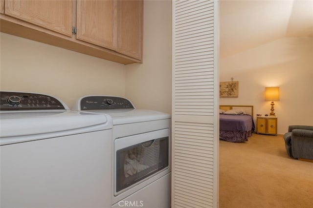 washroom with cabinets, washer and clothes dryer, and light carpet