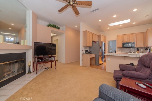 tiled living room with ceiling fan and a fireplace