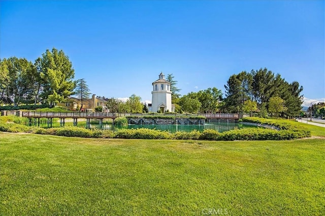 surrounding community with a lawn and a water view