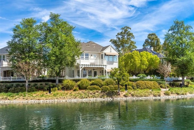 rear view of property featuring a balcony and a water view