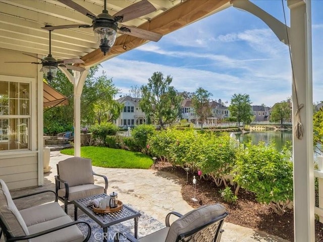 view of patio featuring a water view and ceiling fan