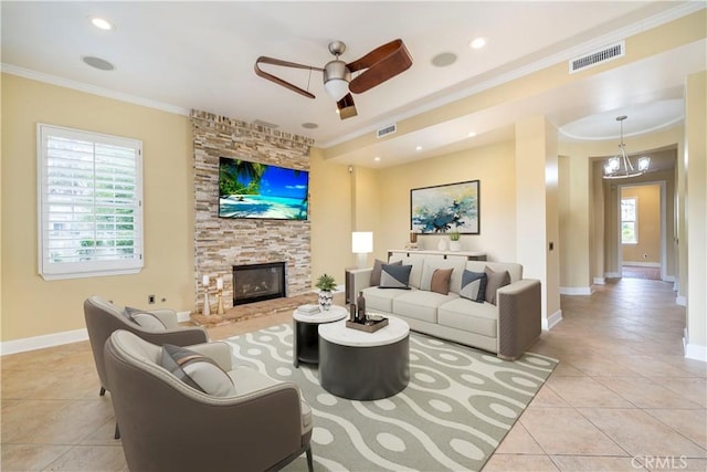 living room featuring a stone fireplace, plenty of natural light, light tile patterned flooring, and ornamental molding