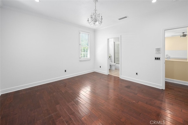 unfurnished room featuring dark hardwood / wood-style floors, ornamental molding, and a chandelier