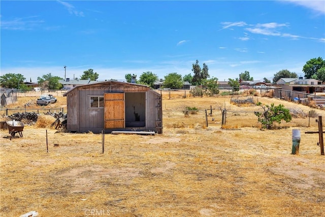 view of yard featuring an outbuilding, a storage shed, and fence