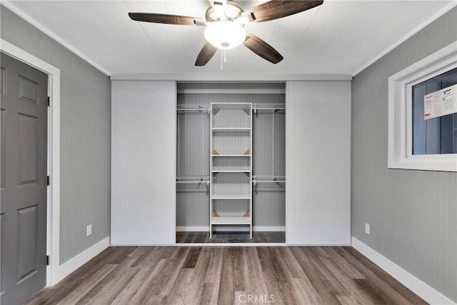 unfurnished bedroom with a closet, ceiling fan, baseboards, and wood finished floors