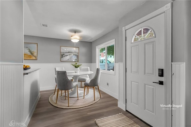 dining space with wood finished floors, visible vents, and baseboards