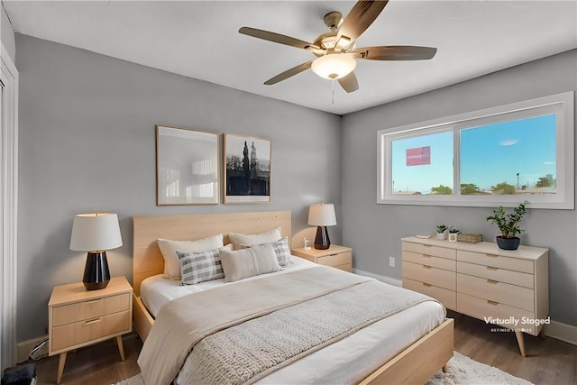 bedroom with ceiling fan, baseboards, and wood finished floors