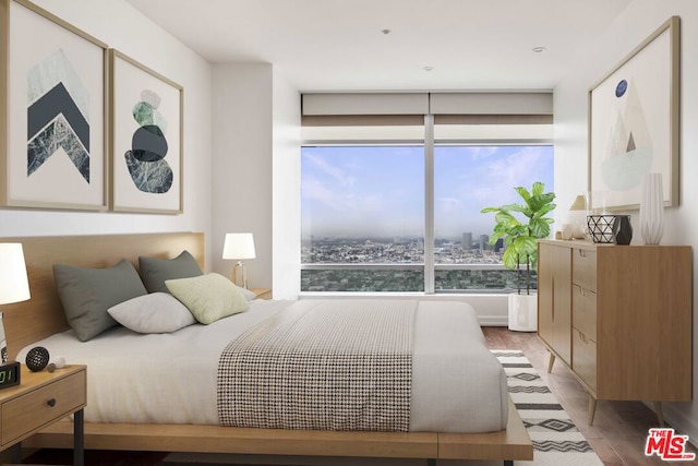 bedroom with a wall of windows and light hardwood / wood-style floors