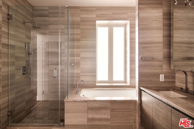 bathroom featuring vanity and separate shower and tub