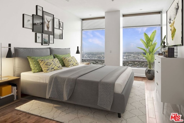 bedroom featuring a wall of windows and hardwood / wood-style flooring