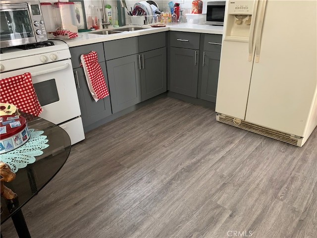 kitchen with gray cabinets, sink, hardwood / wood-style floors, and white appliances