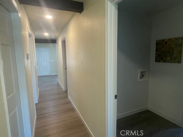 corridor featuring wood-type flooring and beamed ceiling