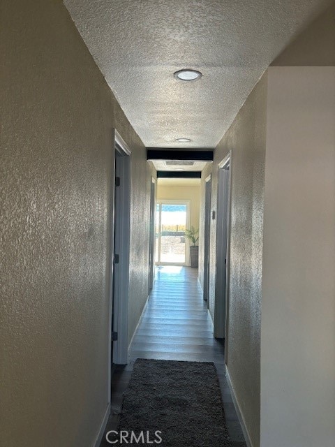 corridor featuring hardwood / wood-style floors and a textured ceiling