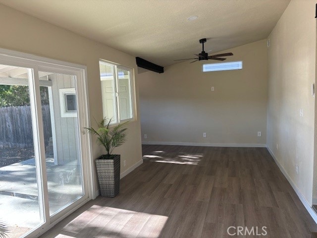 empty room featuring ceiling fan, vaulted ceiling, and dark hardwood / wood-style flooring