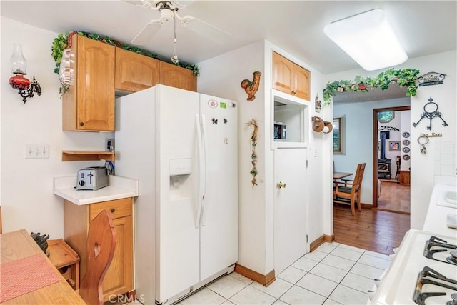 kitchen with light tile patterned floors, white fridge with ice dispenser, and ceiling fan