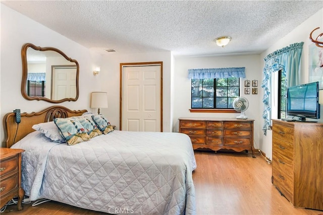 bedroom featuring wood-type flooring and a textured ceiling