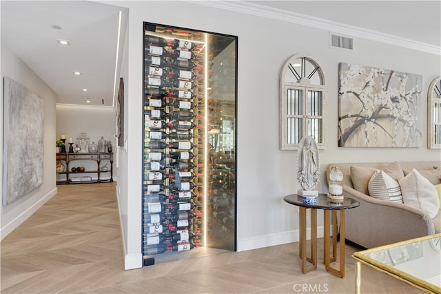 wine area with ornamental molding and light parquet flooring