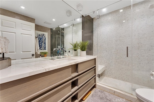 bathroom featuring vanity, toilet, and walk in shower