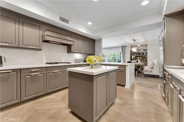 kitchen with gas stovetop, custom range hood, a center island, light parquet floors, and gray cabinets