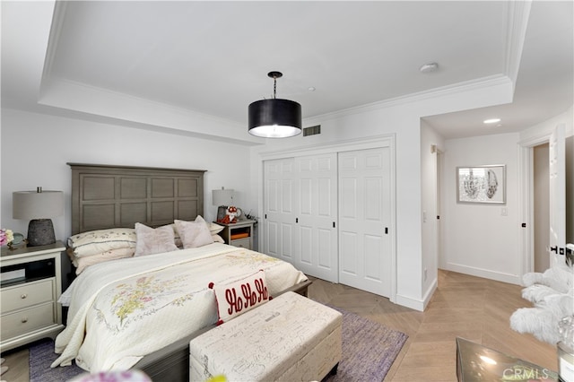 bedroom featuring a closet, ornamental molding, and light parquet floors