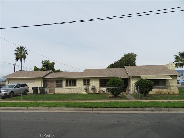 ranch-style home featuring a garage and a front lawn