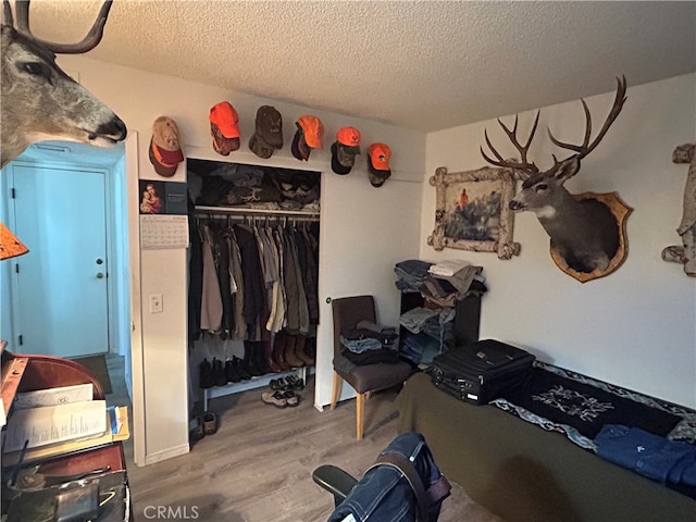 bedroom featuring wood-type flooring, a textured ceiling, and a closet