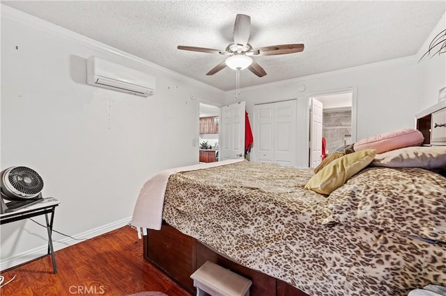 bedroom with dark wood-type flooring, crown molding, ceiling fan, a wall unit AC, and a closet