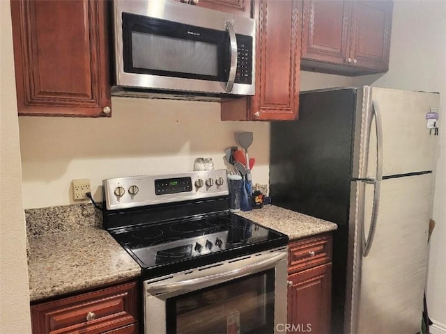 kitchen featuring light stone counters and stainless steel appliances