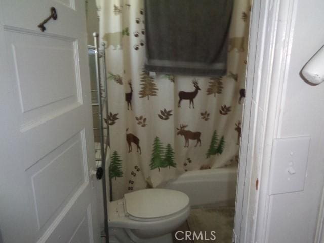 bathroom featuring shower / bath combo with shower curtain and toilet